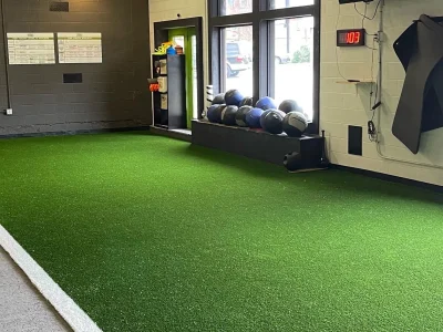 Indoor athletic training turf with exercise equipment in a sports facility in Austin, Texas
