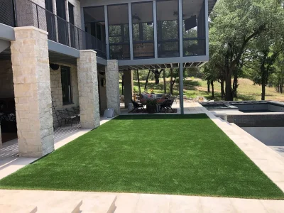 Artificial grass lawn beside a modern swimming pool and covered outdoor living area